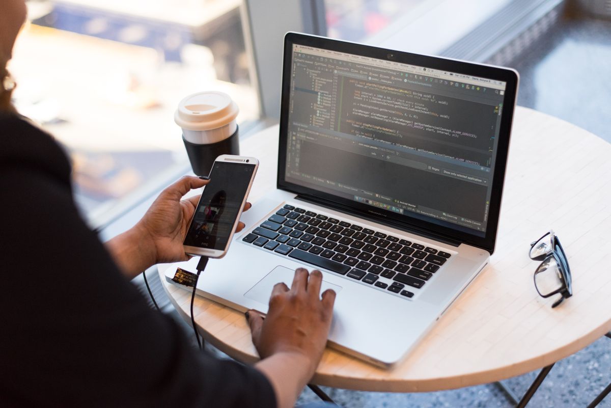 A laptop and phone in use at a table